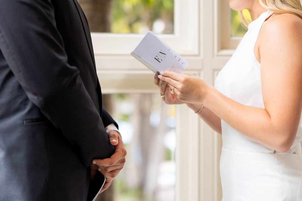 A couple exchanges vows during an intimate wedding ceremony as they read from a ceremony card.