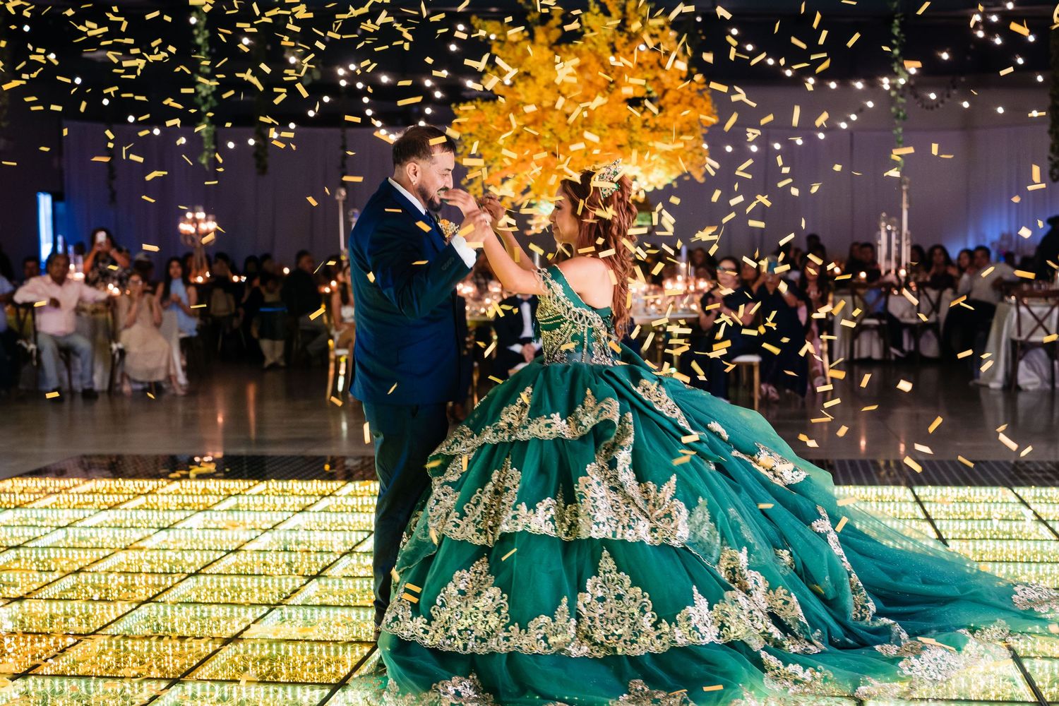 Joyful couple celebrates during quince dance with confetti flying through the air on wooden dance floor.
Charleston, Summerville,SC