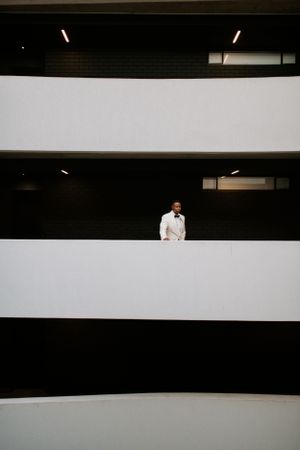 Minimalist architectural photo showing alternating black and white stripes with a figure in white standing in the middle.