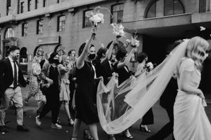 Vintage black and white photo of wedding party celebrating on a city street.