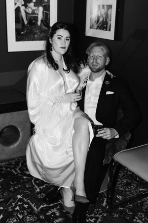 Black and white portrait of a couple relaxing in formal attire.
