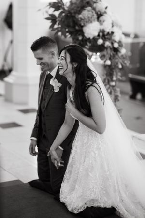 A joyful wedding moment captured in black and white as a couple shares laughter during their celebration.