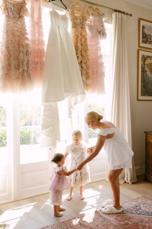 Five sequential photos showing a toddler dancing in sunlit room with white curtains and pink floral decorations.