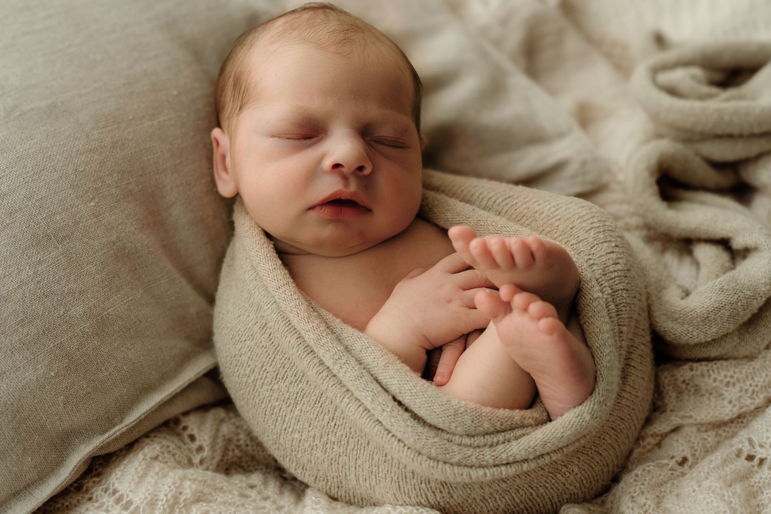 Sleepy newborn wrapped in worm pose