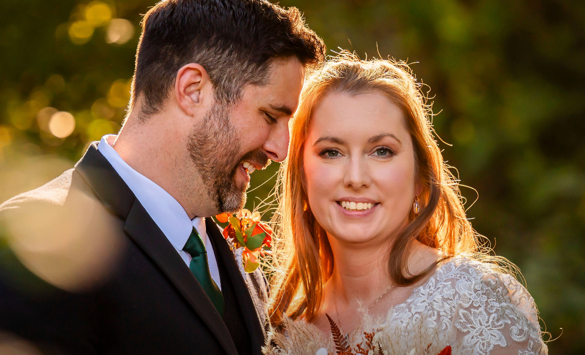 Romantic couple shares an intimate moment with foreheads touching against soft blurred background in their engagement portrait session.
