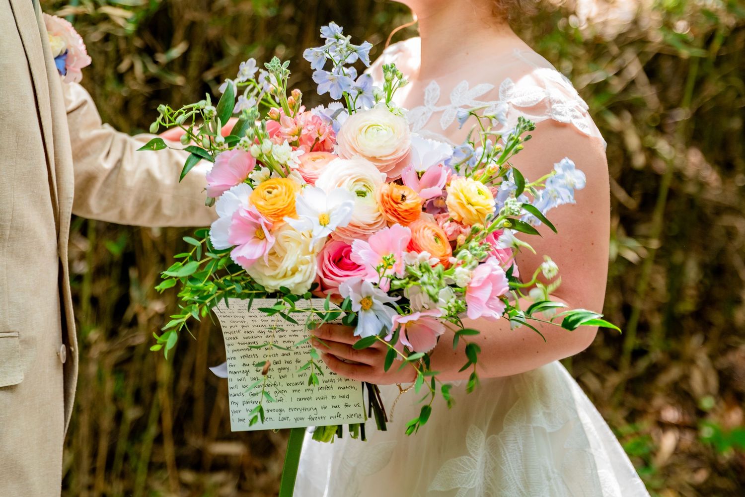 A close-up of a colorful wedding bouquet with a handwritten note.