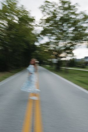 Motion blur photograph of empty road with yellow lines.