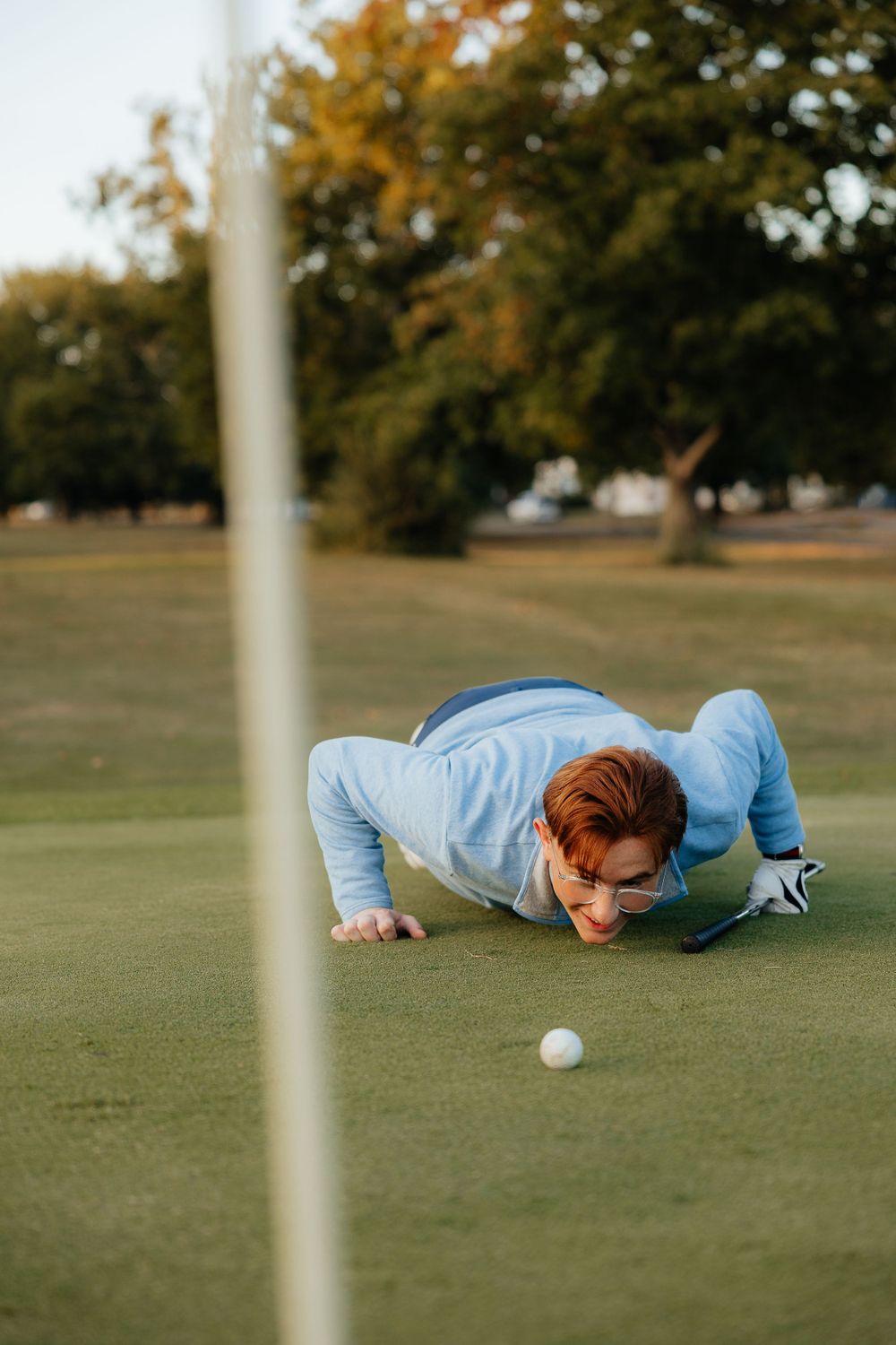 Creative golf photo showing player lying on green studying ball position in Indianapolis, Indiana.