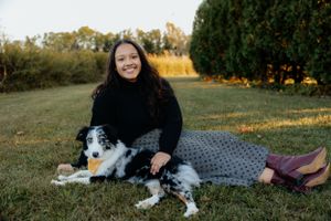 Casual outdoor portrait with Australian Shepherd dog on patterned blanket.