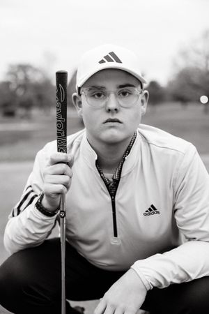 Black and white sports portrait featuring Adidas gear and golf equipment.
