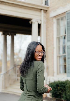 Playful poses near a classical building with white columns and windows.