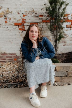 Casual portrait series against a weathered brick wall wearing denim and grey.