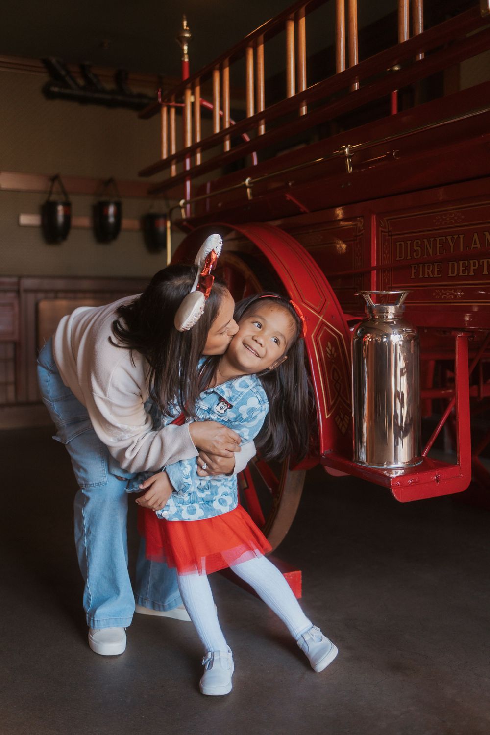 Playful moment captured in front of vintage red decor at Disneyland.