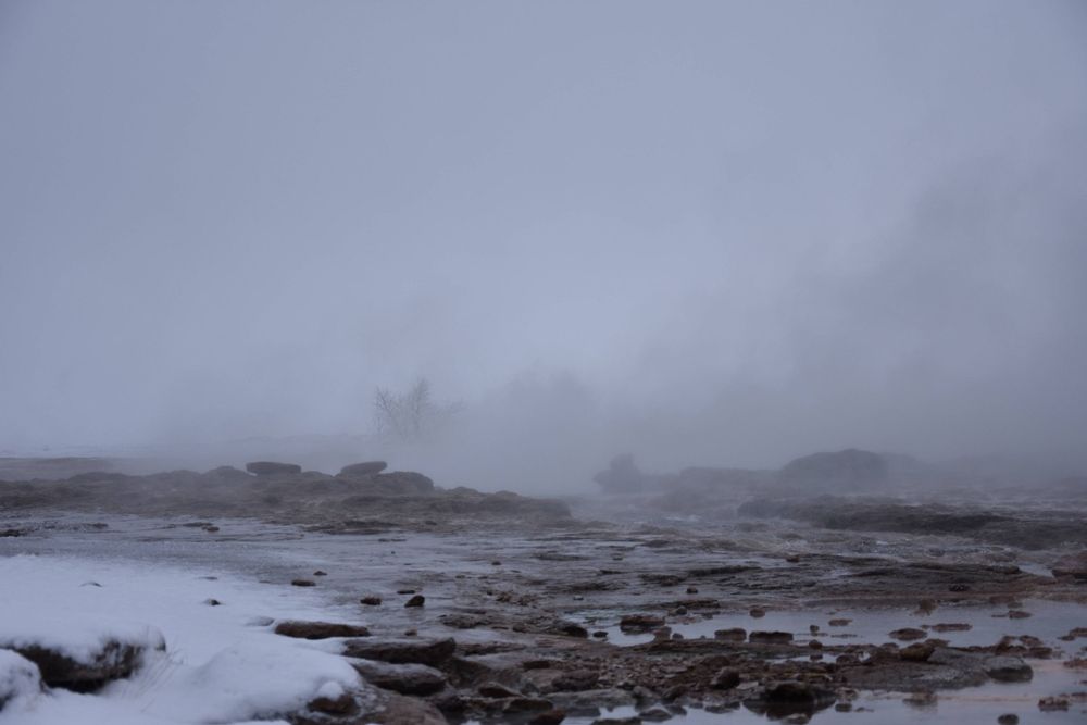 Foggy landscape photograph. rocks and water on the ground.