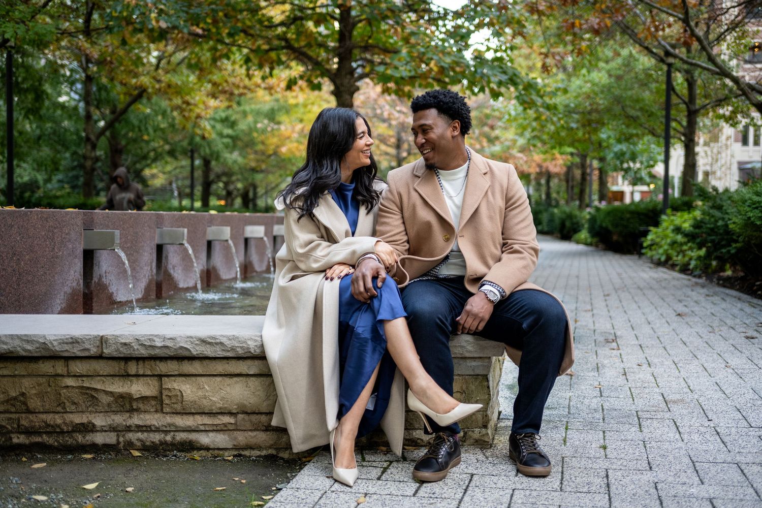 Engagement photo of couple sitting and looking at each other in Lakeshore Park in Chicago.