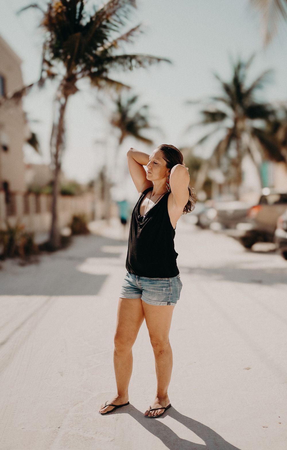 A relaxed summer scene with palm trees and sunlight casting shadows on a beachside walkway photoshoot in Puerto Morelos.