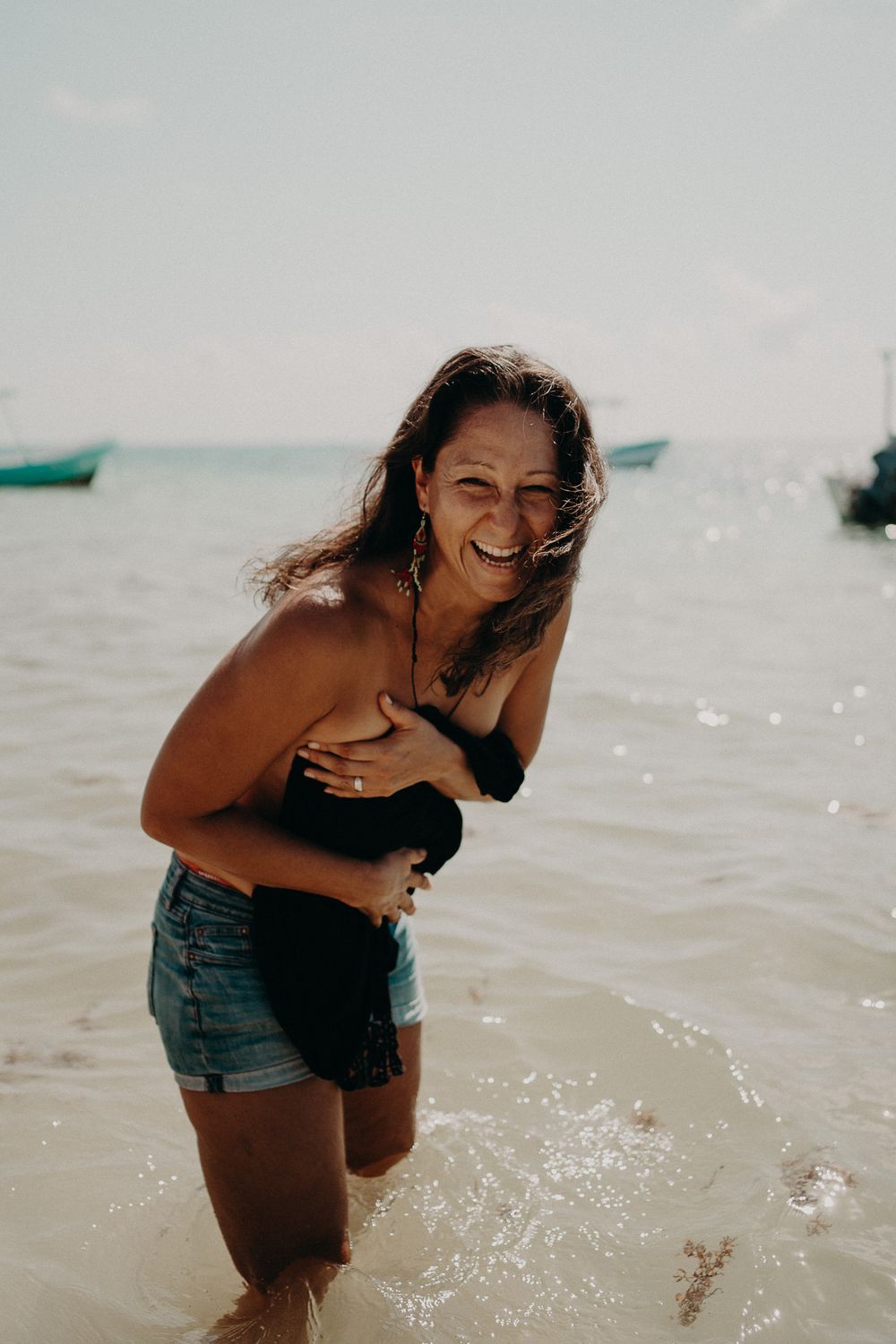 Joyful beach scene with crystal clear waters and boats in the distance photoshoot in Puerto Morelos.