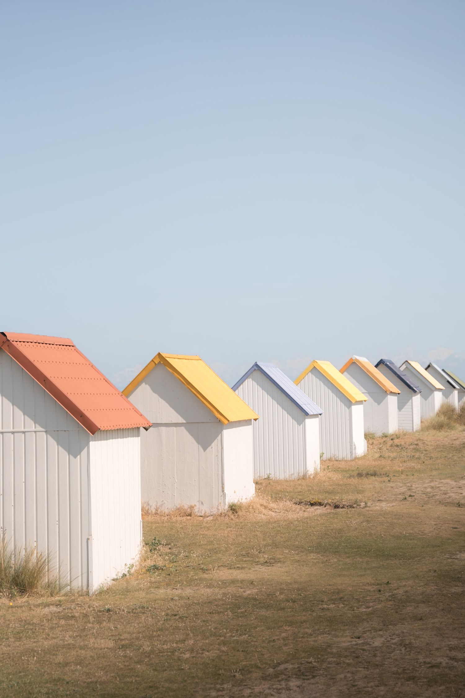 Cabines blanches aux toits colorés à Gouville sur mer 
dans le département de la Manche en Normandie - Cotentin.