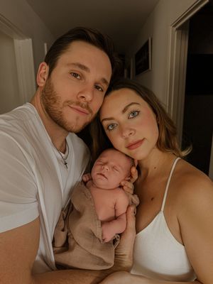 A couple holding their newborn baby in an intimate family portrait.