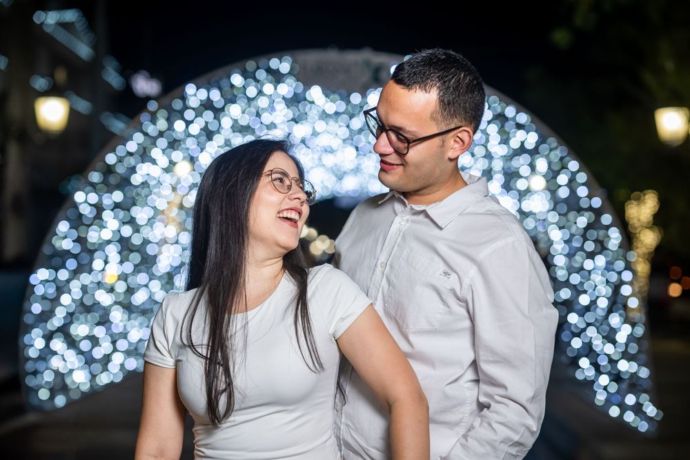 Couple sharing a laugh together in front of illuminated blue light display.