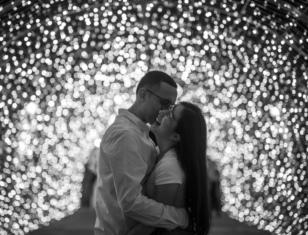 Black and white intimate portrait of couple with bokeh light background.