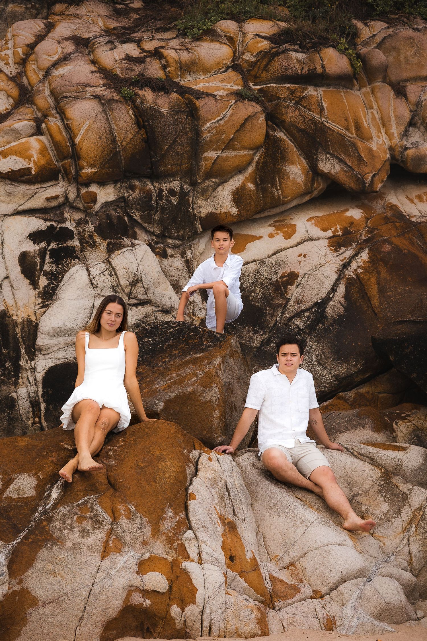 Candid family portrait on the beach at coolum, Sunshine Coast, with the soft glow of morning sunlight and the sound of the ocean in the back