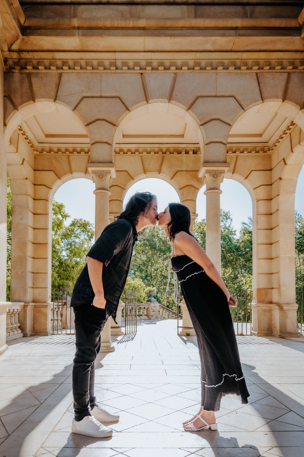 Couple laughing together as they walk through the park.