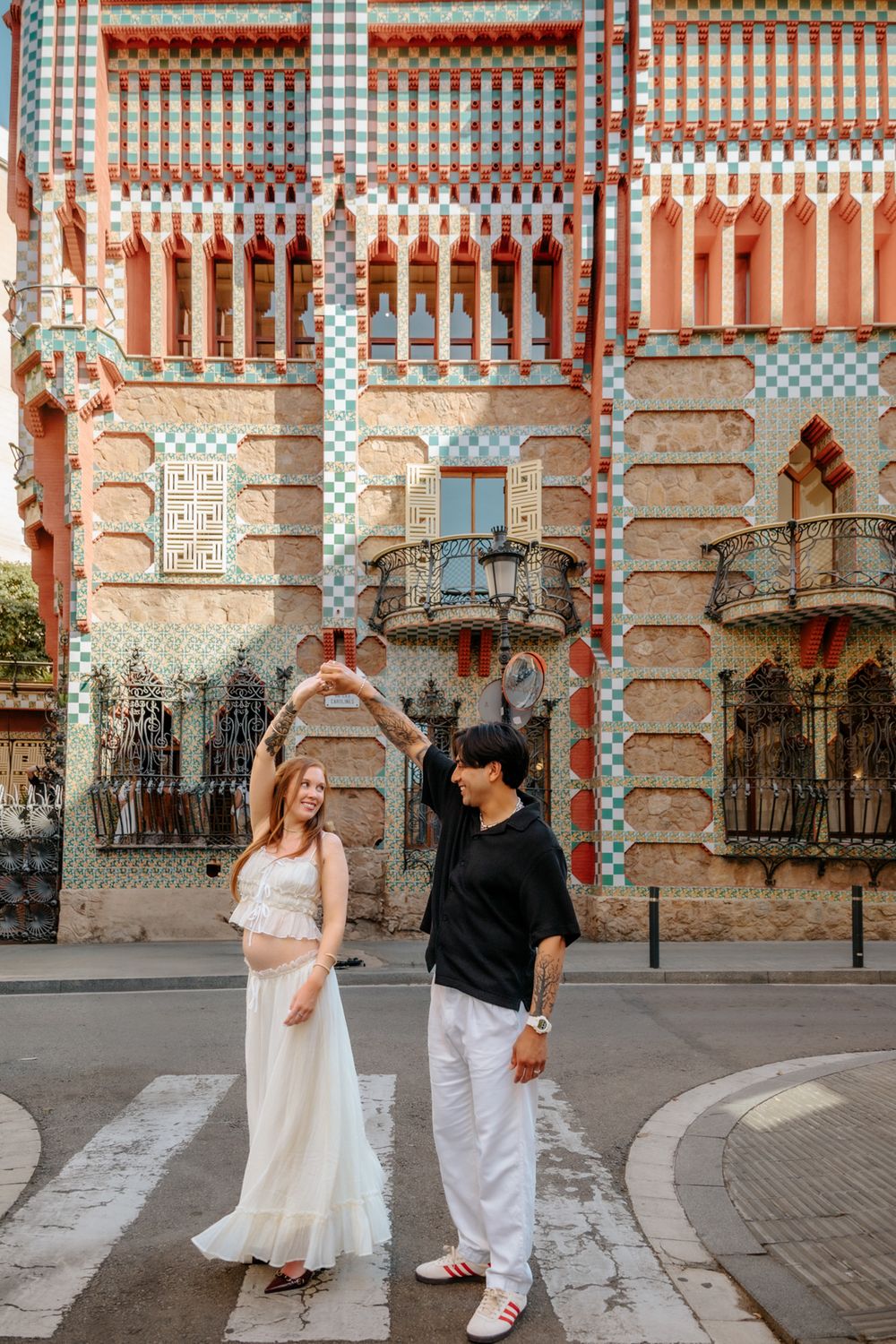 Couple sharing laughter during their maternity session at Casa Vicens.