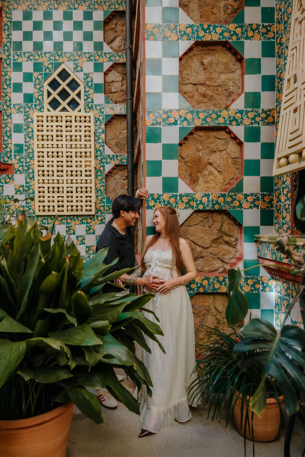 Sweet candid maternity moment of Jenna & Juan smiling at Casa Vicens.