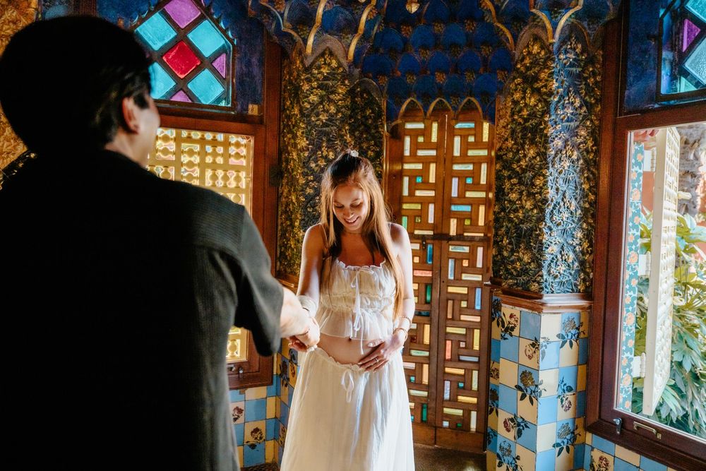 Candid maternity laughter surrounded by Gaudí’s artistry.