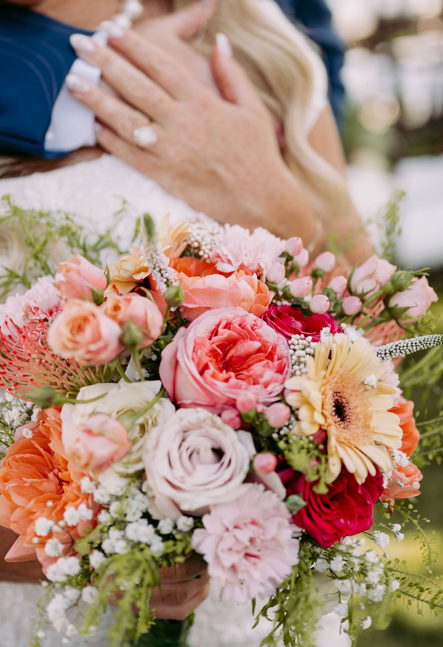A romantic floral arrangement with pink and peach roses mixed with delicate greenery.