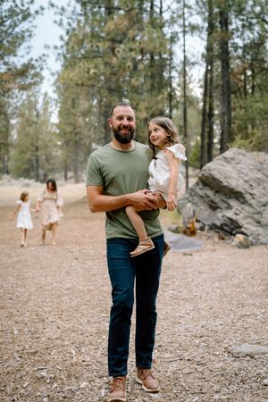 Candid family moments captured in a pine forest setting with natural rock formations.