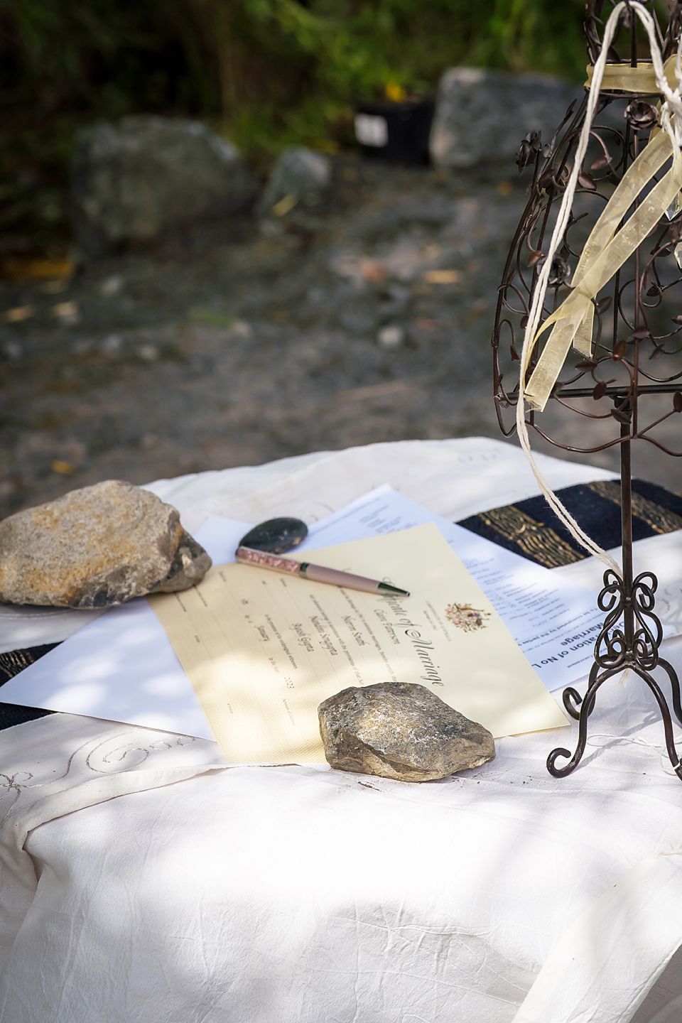 Paper on a white surface with decorative metal stands and rocks displayed as natural paperweights.