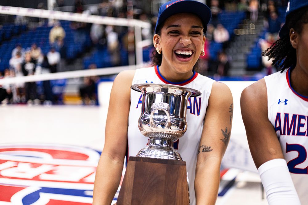 Athlete celebrates with championship trophy after winning tournament.