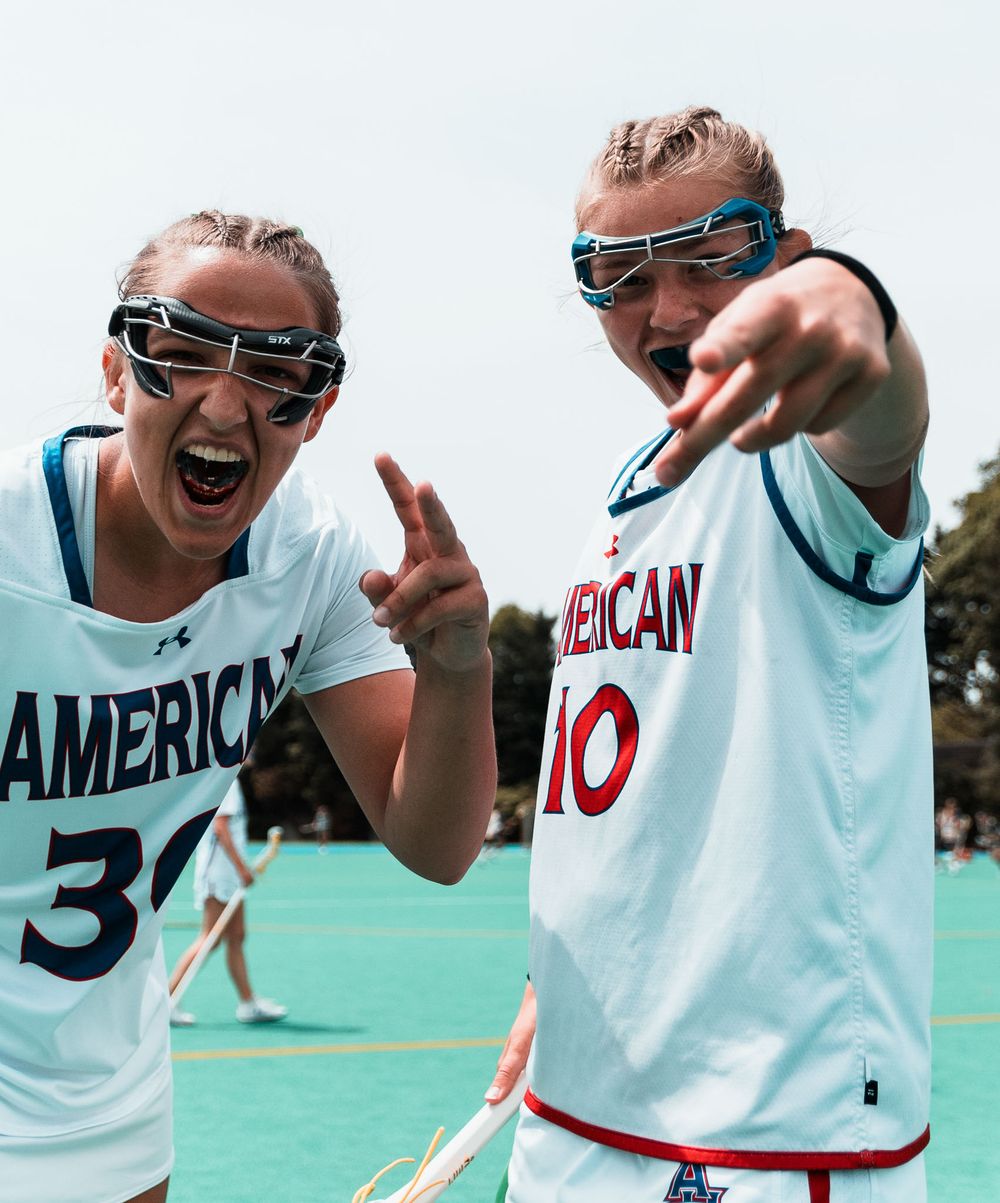 Two athletes in American team uniforms pose excitedly wearing protective eyewear.