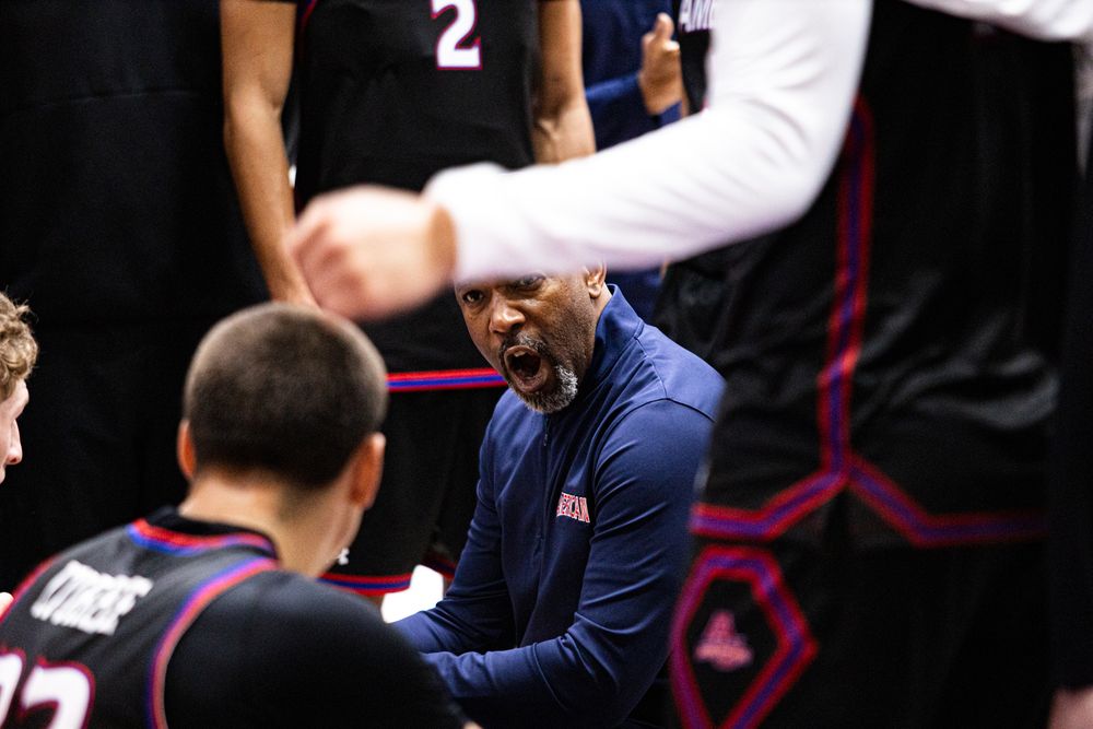 Coach gives instruction to team during basketball game timeout.