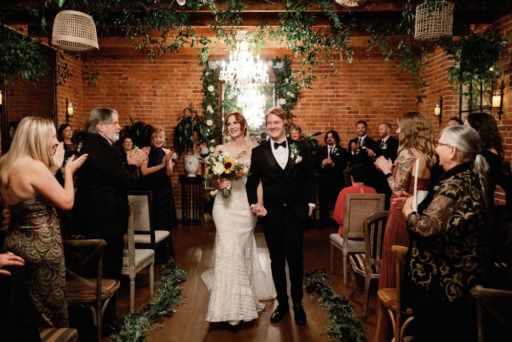 Bride and groom joyfully walking back down the aisle after their wedding ceremony.