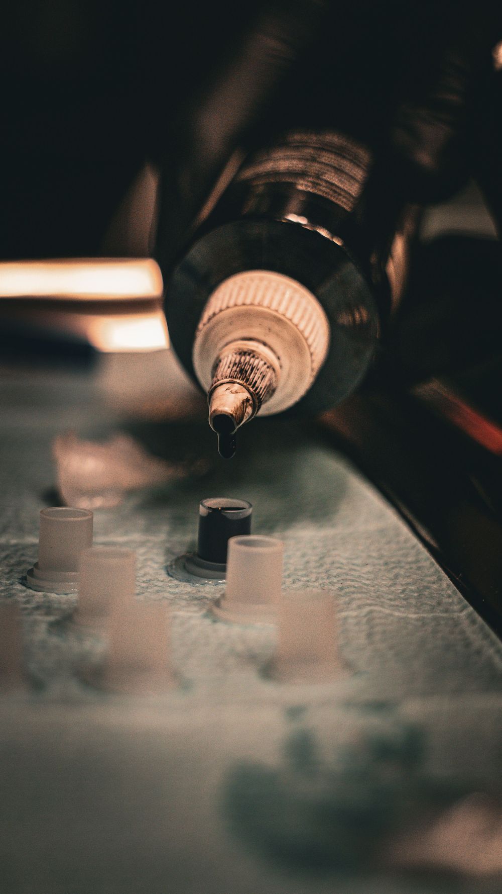 Close-up of tattoo needles working in dark atmospheric lighting.