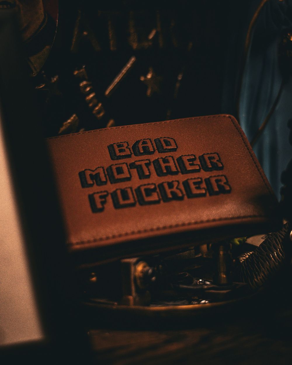 Leather wallet or case with embossed text in dramatic lighting.