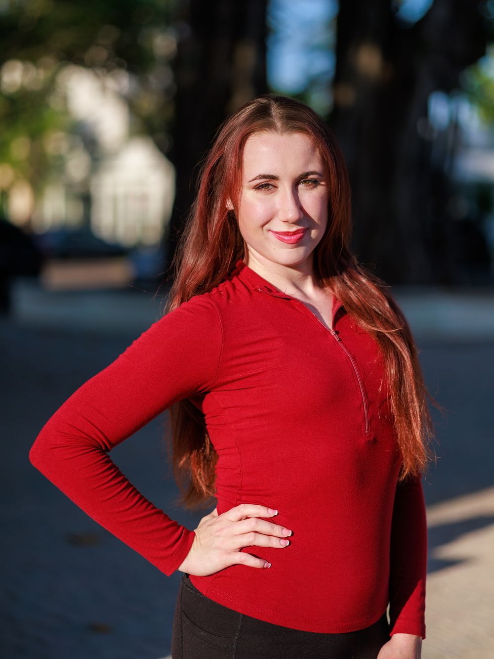 A series of fashion poses in a red long-sleeved top against an outdoor urban background.