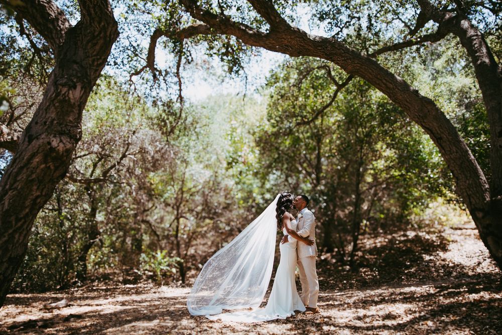 Chapel of Orange Wedding Photo of bride and groom kissing under the trees.