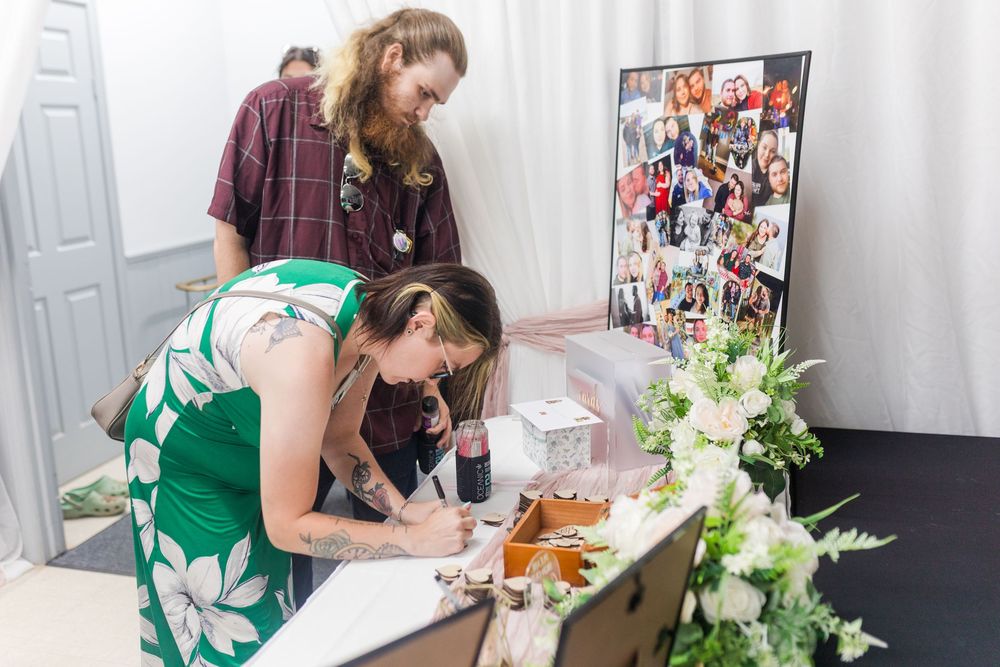 People in green aprons prepare flowers and bouquets at long tables during a floral arranging workshop.