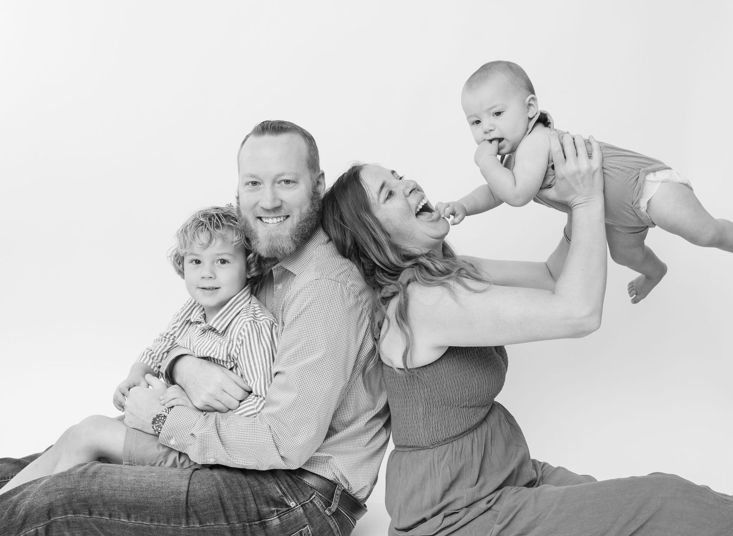 Black and white family photoshoot sequence showing playful interactions.