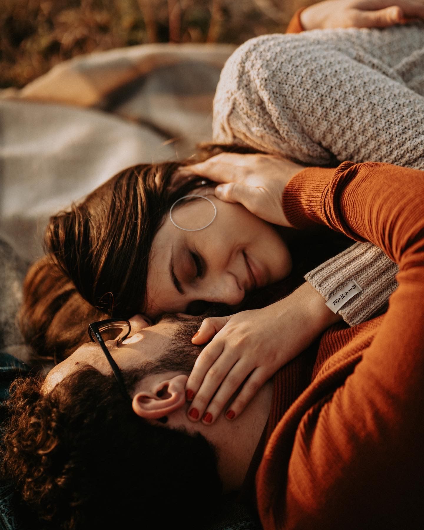 Close-up shot of couple sharing intimate moment in warm autumn lighting.