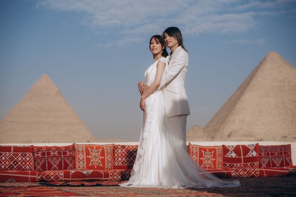 A desert wedding photoshoot featuring white dresses against the backdrop of the ancient Egyptian pyramids.