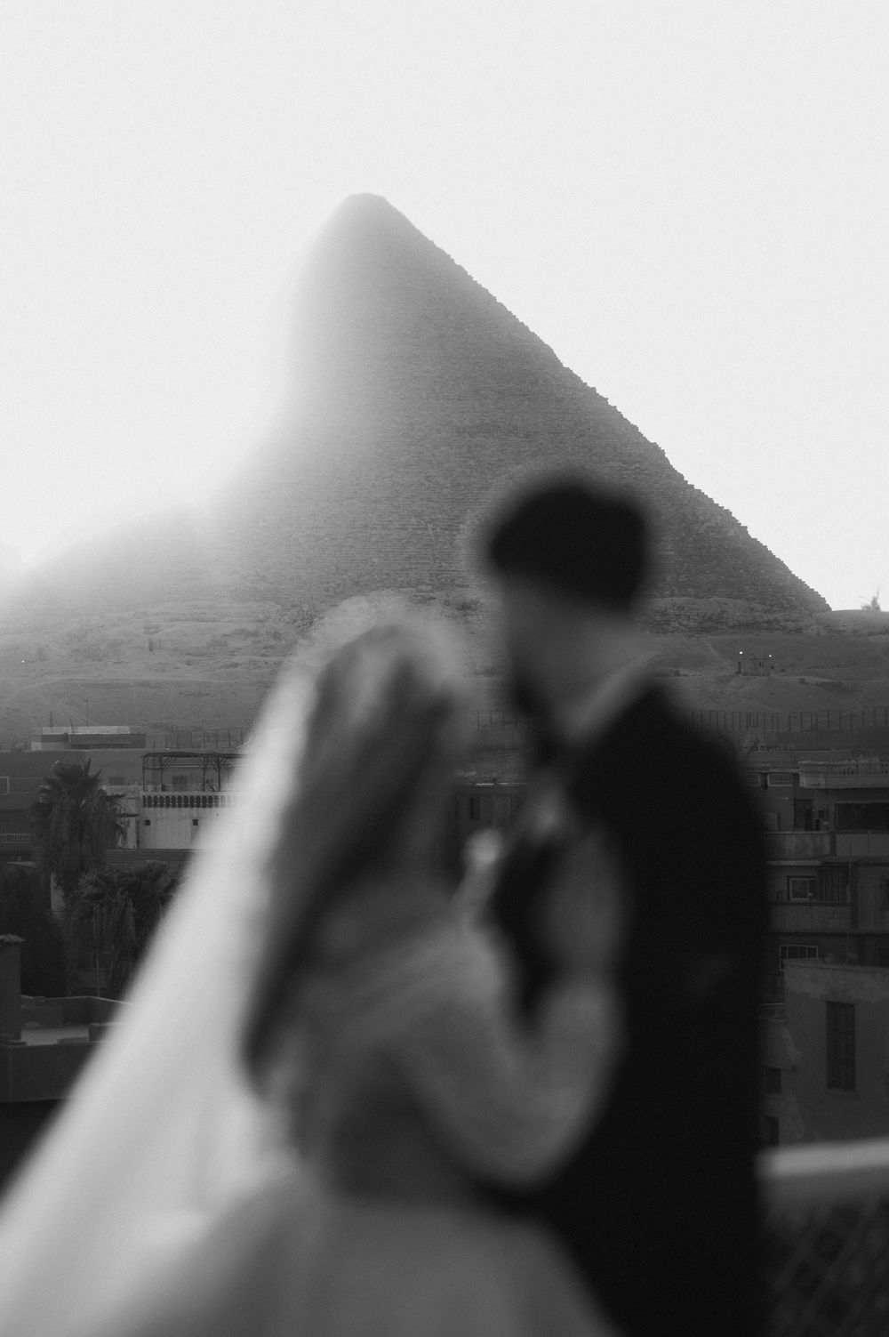 A sequence of blurry black and white landscape images showing mountains and buildings in the background.
