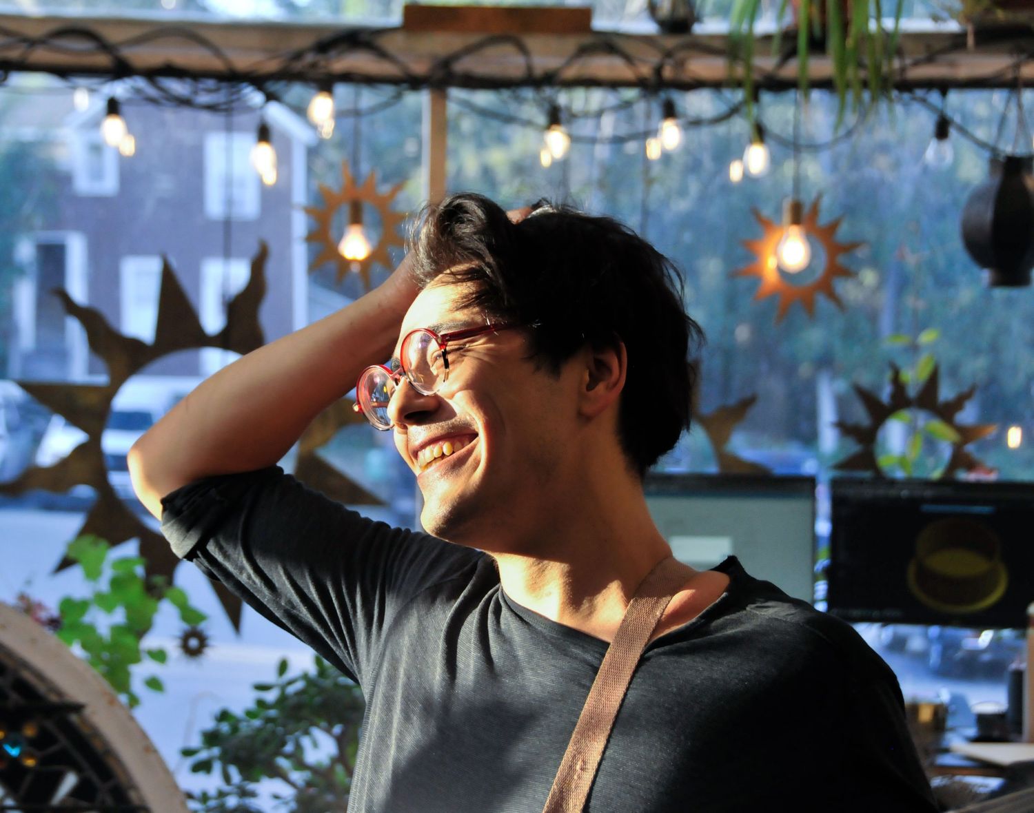 Man smiles while posing in golden hour light during portrait photography session.