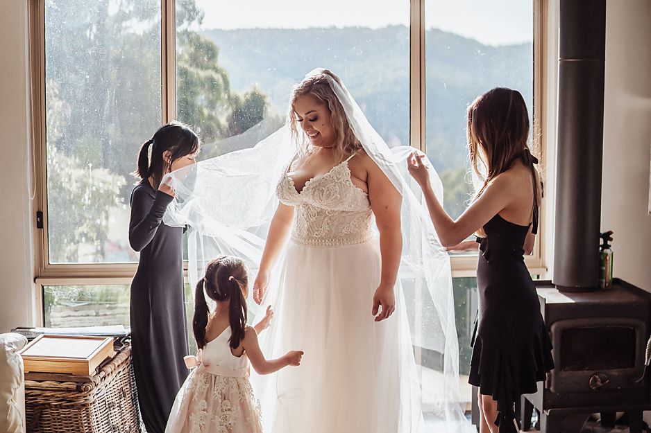 Wedding party getting ready in elegant room with snow covered mountain views through large windows in background.