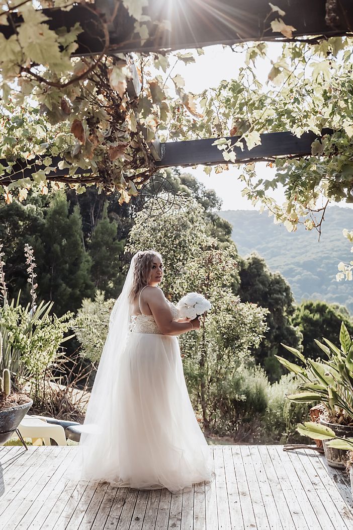 A sequence of ethereal wedding dress photos captured on a sunlit outdoor deck with mountain views in the background.