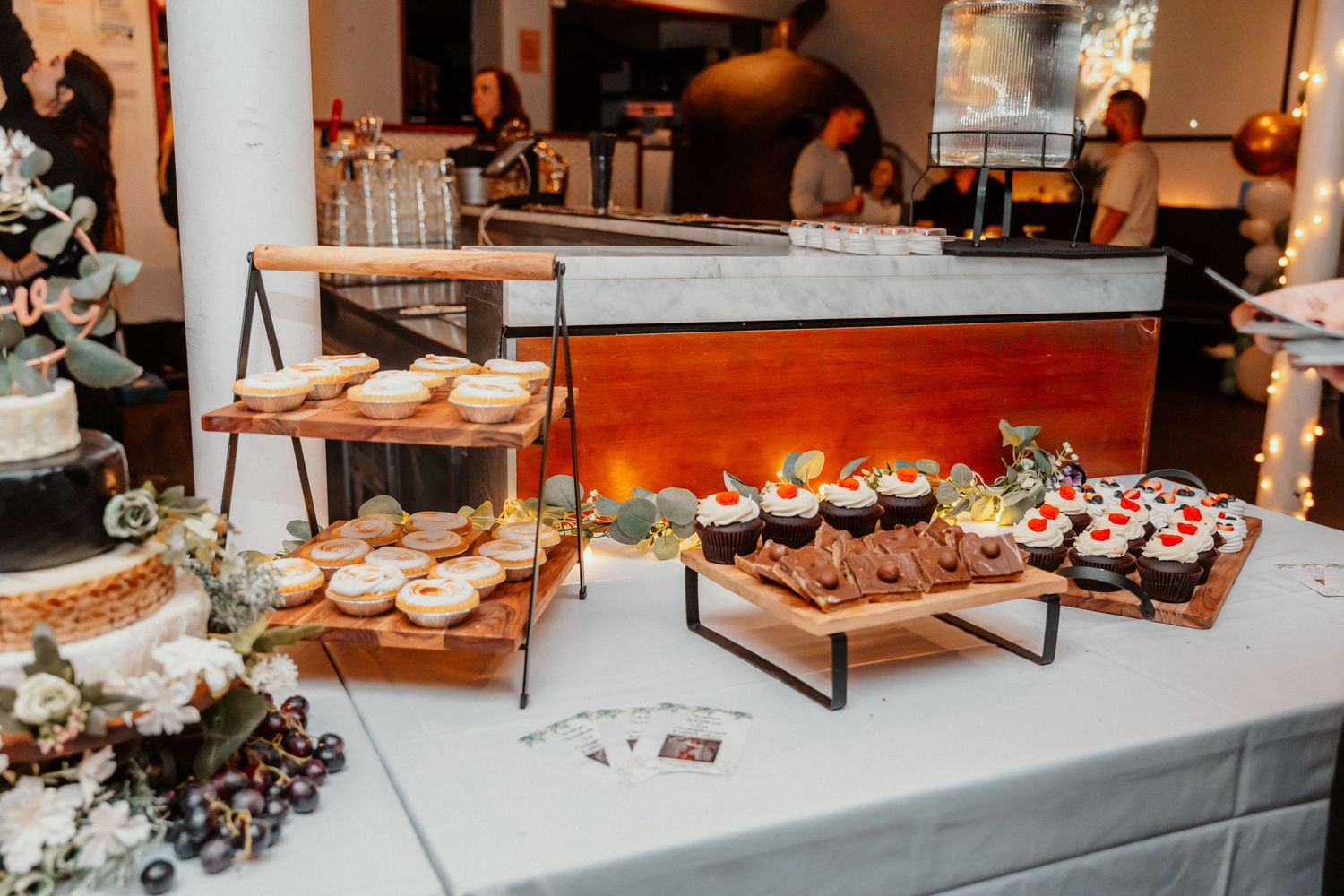 Elegant catering display featuring assorted appetizers, sushi rolls, and hors d'oeuvres arranged on modern platters and stands.